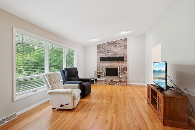 11600 Oberlin Rd, Minnetonka, MN 55305 - living room with vaulted ceiling, light wood-style flooring, a brick fireplace, and baseboards