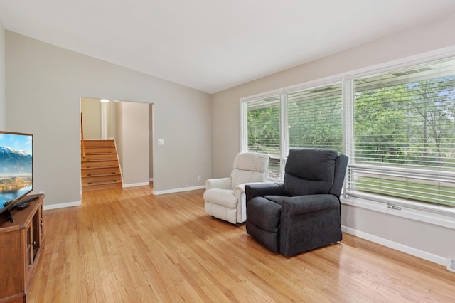11600 Oberlin Rd, Minnetonka, MN 55305 - living area featuring light wood finished floors, stairway, vaulted ceiling, and baseboards