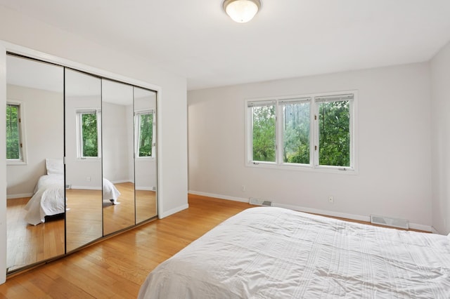 11600 Oberlin Rd, Minnetonka, MN 55305 - bedroom with multiple windows, light wood-type flooring, and baseboards