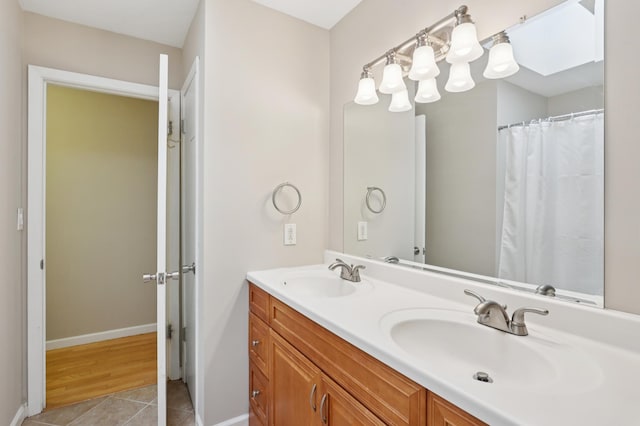 11600 Oberlin Rd, Minnetonka, MN 55305 - bathroom with double vanity, tile patterned floors, and baseboards