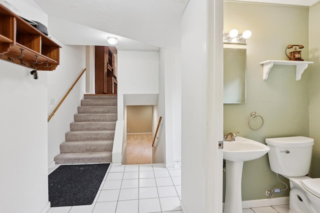 11600 Oberlin Rd, Minnetonka, MN 55305 - half bathroom featuring toilet, baseboards, tile patterned floors, and a sink