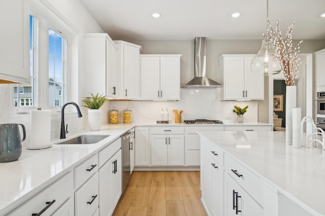 9874 49th St NE, Saint Michael, MN 55376 - kitchen with wall chimney exhaust hood, a sink, light countertops, white cabinetry, and light wood-style floors
