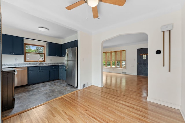 5257 27th Ave S, Minneapolis, MN 55417 - kitchen featuring stainless steel appliances, arched walkways, plenty of natural light, and light countertops