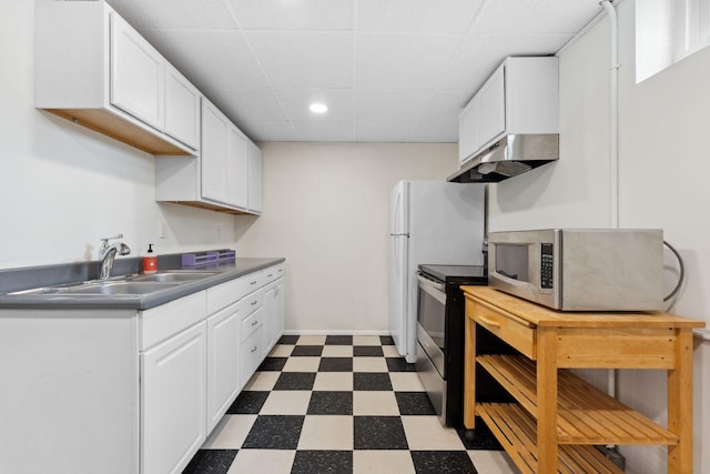 5257 27th Ave S, Minneapolis, MN 55417 - kitchen featuring appliances with stainless steel finishes, under cabinet range hood, dark flooring, a sink, and white cabinets