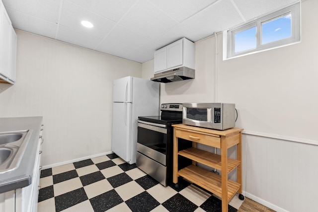 5257 27th Ave S, Minneapolis, MN 55417 - kitchen with stainless steel appliances, under cabinet range hood, light flooring, white cabinetry, and a paneled ceiling