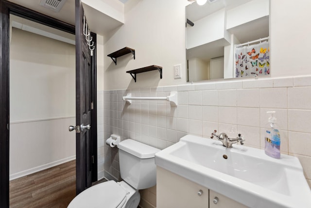5257 27th Ave S, Minneapolis, MN 55417 - bathroom featuring toilet, tile walls, vanity, wood finished floors, and wainscoting