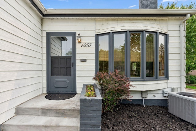 5257 27th Ave S, Minneapolis, MN 55417 - view of exterior entry with central air condition unit and a chimney