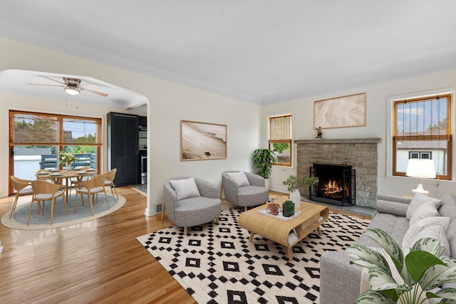 5257 27th Ave S, Minneapolis, MN 55417 - living room featuring wood finished floors, ceiling fan, a warm lit fireplace, and arched walkways