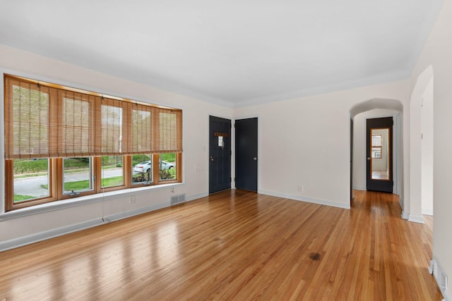 5257 27th Ave S, Minneapolis, MN 55417 - empty room featuring light wood-style floors, arched walkways, and baseboards