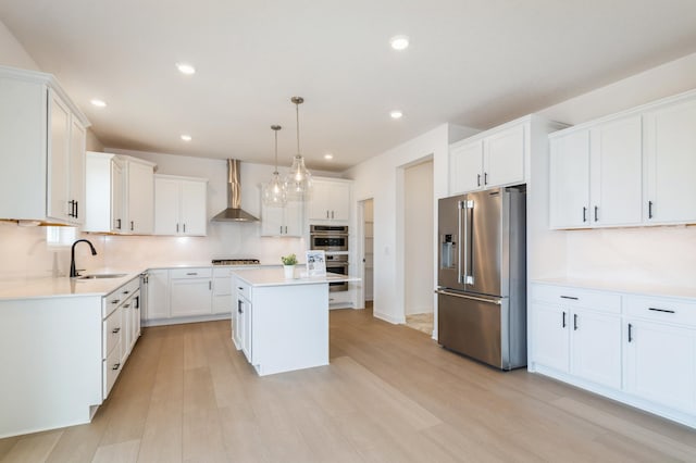 9887 49th St NE, Saint Michael, MN 55376 - kitchen with stainless steel appliances, wall chimney range hood, a sink, light wood-type flooring, and a kitchen island