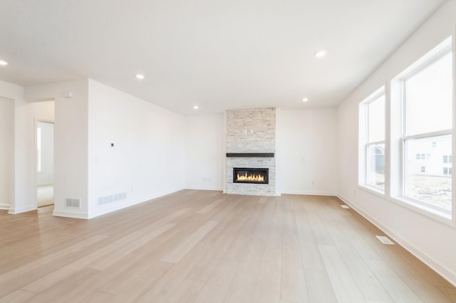 9887 49th St NE, Saint Michael, MN 55376 - unfurnished living room featuring light wood-style flooring, a stone fireplace, recessed lighting, and baseboards