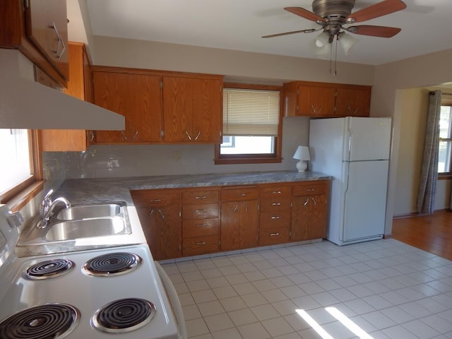 1052 36th Ave N, Saint Cloud, MN 56303 - kitchen with freestanding refrigerator, brown cabinets, a sink, light tile patterned flooring, and a ceiling fan