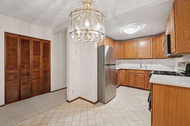 6670 Vernon Ave S Unit 301, Edina, MN 55436 - kitchen featuring appliances with stainless steel finishes, a sink, a chandelier, light countertops, and baseboards