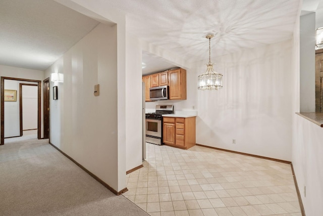 6670 Vernon Ave S Unit 301, Edina, MN 55436 - kitchen with stainless steel appliances, baseboards, light countertops, and a chandelier