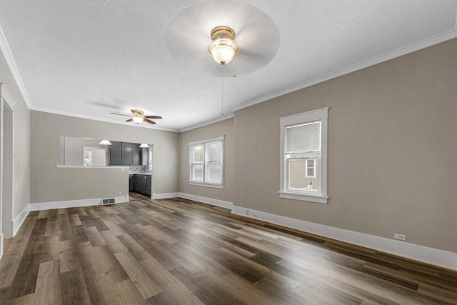 2939 Linden Ave, Slayton, MN 56172 - unfurnished living room featuring ceiling fan, dark wood-style floors, crown molding, baseboards, and a textured ceiling
