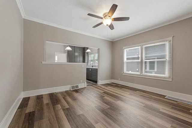 2939 Linden Ave, Slayton, MN 56172 - empty room featuring a ceiling fan, dark wood-type flooring, crown molding, baseboards, and a sink