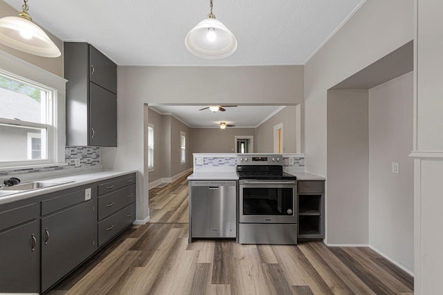 2939 Linden Ave, Slayton, MN 56172 - kitchen featuring stainless steel appliances, backsplash, wood finished floors, light countertops, and crown molding