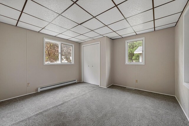 2939 Linden Ave, Slayton, MN 56172 - unfurnished bedroom featuring baseboard heating, carpet flooring, a drop ceiling, and baseboards