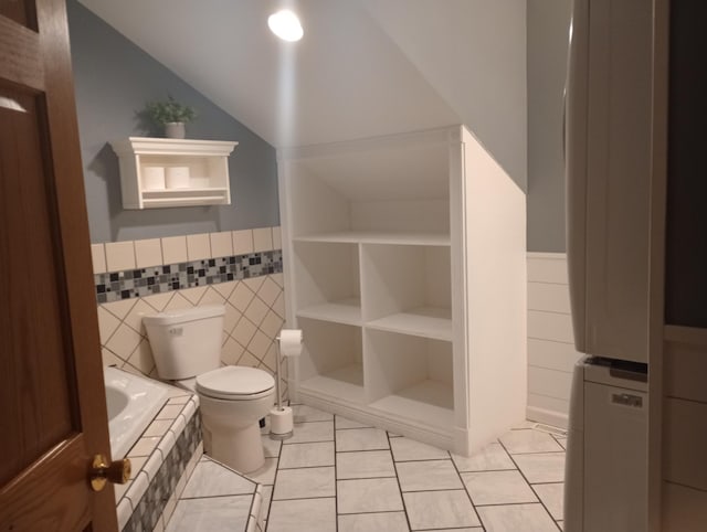232 2nd St NW, Menahga, MN 56464 - bathroom featuring wainscoting, lofted ceiling, tiled bath, and tile patterned floors