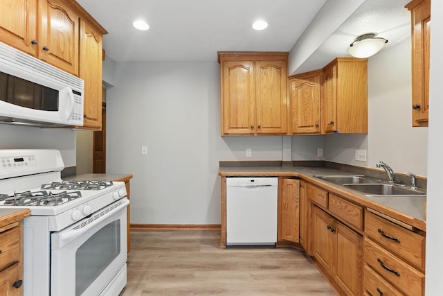 11001 Quincy Blvd NE, Blaine, MN 55434 - kitchen with white appliances, a sink, recessed lighting, light wood-type flooring, and baseboards