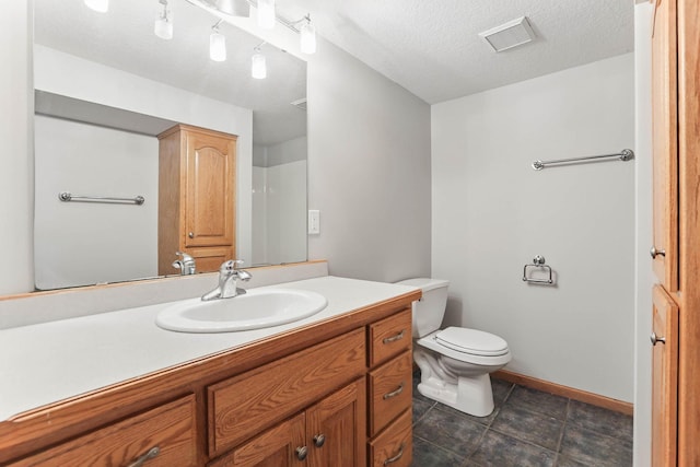 11001 Quincy Blvd NE, Blaine, MN 55434 - full bathroom featuring vanity, toilet, tile patterned flooring, a textured ceiling, and baseboards