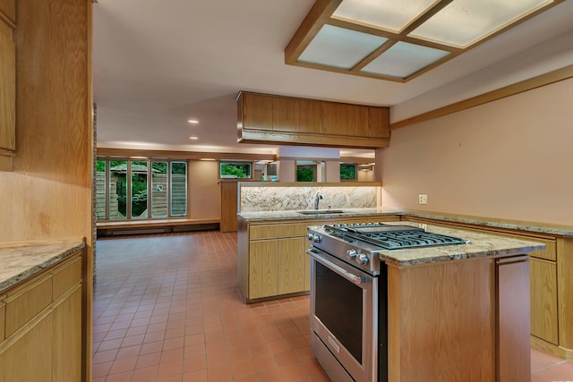 398 Riverside Ave S, Sartell, MN 56377 - kitchen with high end stainless steel range, a sink, light tile patterned floors, a kitchen island, and light stone counters