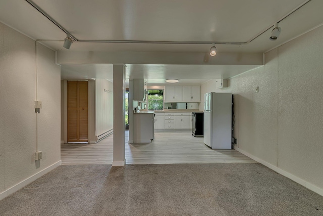 398 Riverside Ave S, Sartell, MN 56377 - unfurnished living room featuring rail lighting, a textured wall, light colored carpet, baseboard heating, and baseboards