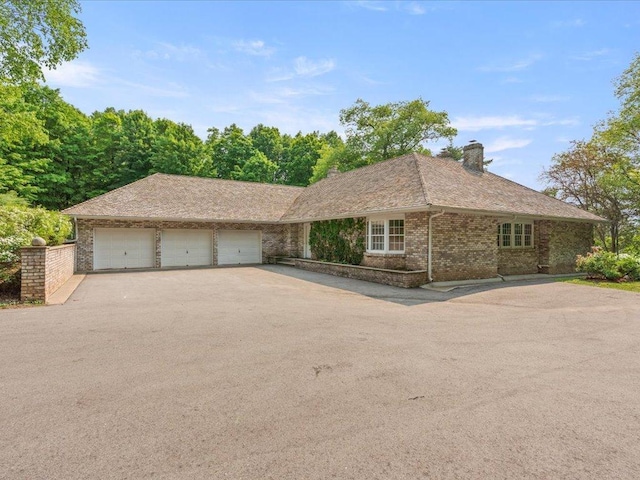 8821 Interlachen Rd, Lake Shore, MN 56468 - ranch-style home with asphalt driveway, a garage, brick siding, and a chimney