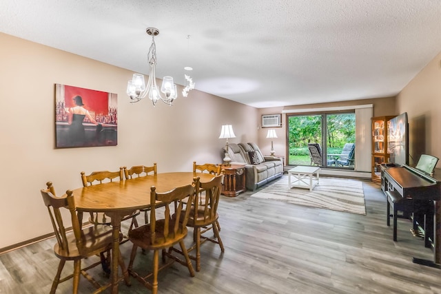1855 Silver Bell Rd Unit 120, Eagan, MN 55122 - dining space with a wall mounted AC, a chandelier, wood finished floors, and a textured ceiling