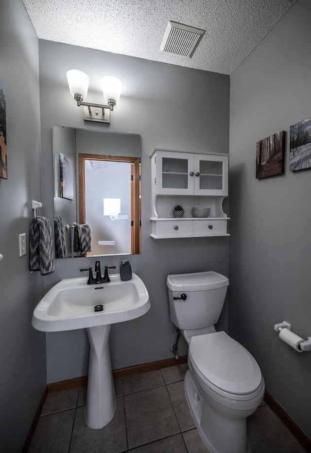 15608 Fjord Ave, Apple Valley, MN 55124 - bathroom with toilet, tile patterned flooring, a textured ceiling, baseboards, and a sink