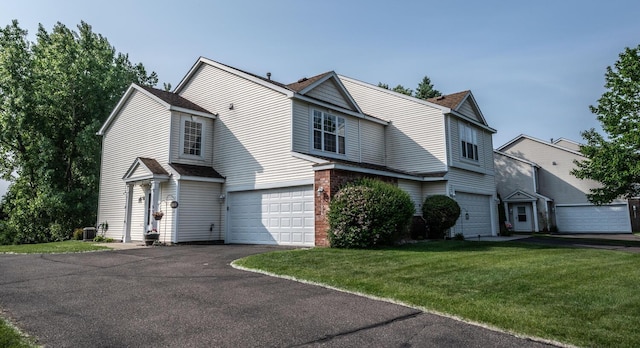 15608 Fjord Ave, Apple Valley, MN 55124 - traditional home with an attached garage, asphalt driveway, a front yard, cooling unit, and a shingled roof