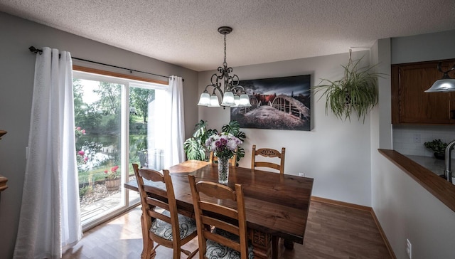 15608 Fjord Ave, Apple Valley, MN 55124 - dining area with a chandelier, a textured ceiling, light wood-type flooring, and baseboards