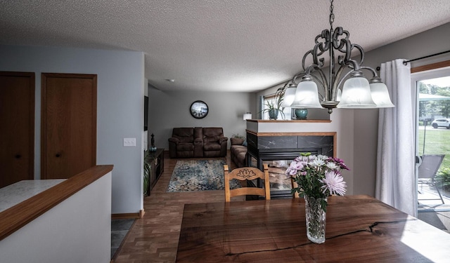15608 Fjord Ave, Apple Valley, MN 55124 - dining space featuring a chandelier, a textured ceiling, a fireplace, and wood finished floors