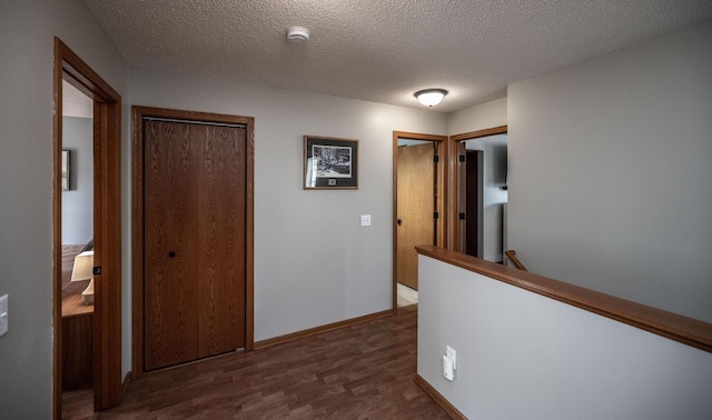 15608 Fjord Ave, Apple Valley, MN 55124 - corridor featuring dark wood-style floors, a textured ceiling, an upstairs landing, and baseboards