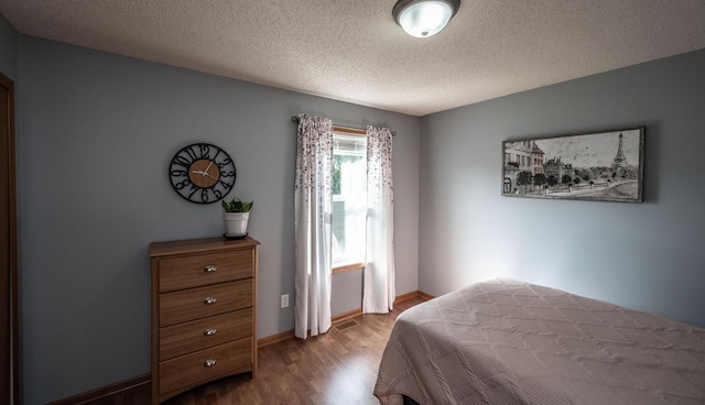 15608 Fjord Ave, Apple Valley, MN 55124 - bedroom featuring wood finished floors, a textured ceiling, and baseboards
