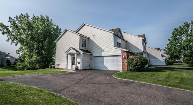 15608 Fjord Ave, Apple Valley, MN 55124 - traditional-style house featuring driveway, an attached garage, a front lawn, and brick siding