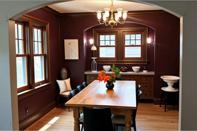 145 Robie St W, Saint Paul, MN 55107 - dining area featuring arched walkways, a chandelier, light wood-style floors, plenty of natural light, and crown molding
