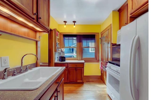 145 Robie St W, Saint Paul, MN 55107 - kitchen featuring white appliances, a sink, light wood finished floors, and brown cabinets