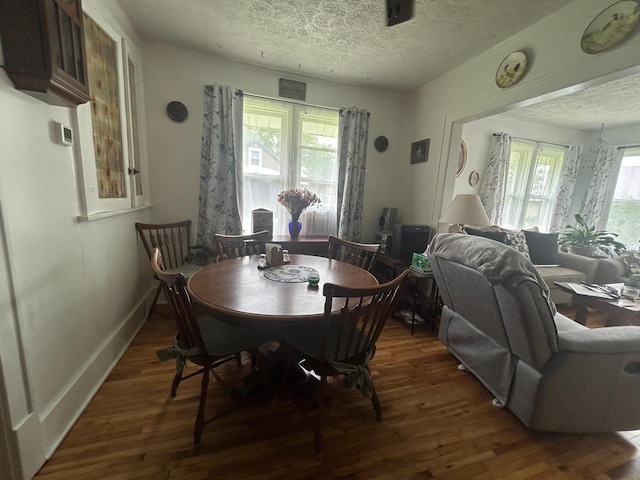 207 Cook St, Palisade, MN 56469 - dining area featuring wood finished floors and a textured ceiling