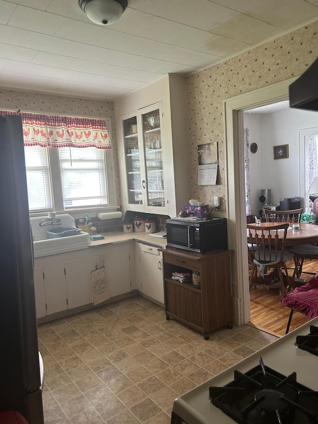 207 Cook St, Palisade, MN 56469 - kitchen featuring black microwave, freestanding refrigerator, range, light countertops, and wallpapered walls