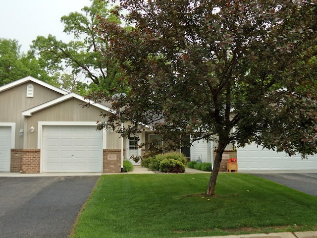 14257 184th Ave NW, Elk River, MN 55330 - view of front of house with brick siding, a front yard, driveway, and an attached garage