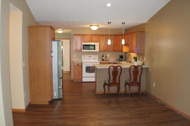 14257 184th Ave NW, Elk River, MN 55330 - kitchen featuring white appliances, a sink, a peninsula, dark wood-style flooring, and recessed lighting
