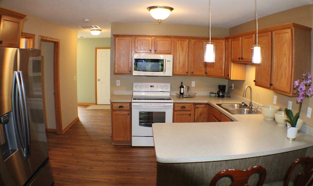 14257 184th Ave NW, Elk River, MN 55330 - kitchen with white appliances, a sink, light countertops, dark wood-style flooring, and a peninsula