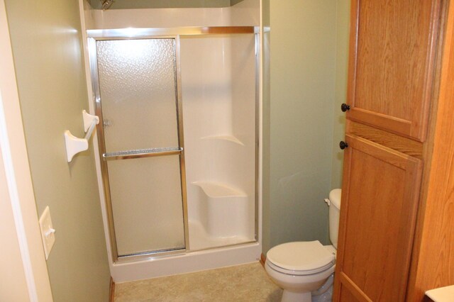 14257 184th Ave NW, Elk River, MN 55330 - bathroom featuring a stall shower, toilet, and baseboards