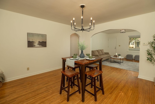 1126 7th Ave SE, Rochester, MN 55904 - dining area with arched walkways, a chandelier, and light wood-style flooring
