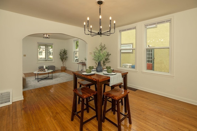 1126 7th Ave SE, Rochester, MN 55904 - dining room with arched walkways, wood-type flooring, and a chandelier