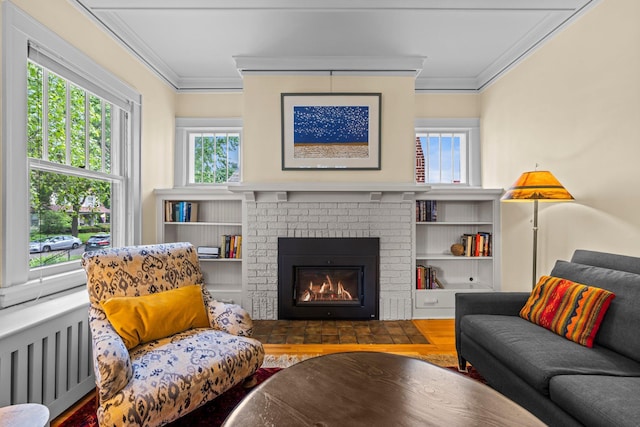 4817 Emerson Ave S, Minneapolis, MN 55419 - living area featuring ornamental molding, plenty of natural light, radiator heating unit, a brick fireplace, and wood finished floors