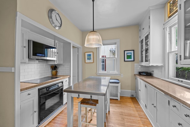 4817 Emerson Ave S, Minneapolis, MN 55419 - kitchen with black appliances, decorative backsplash, light wood-style flooring, and white cabinetry