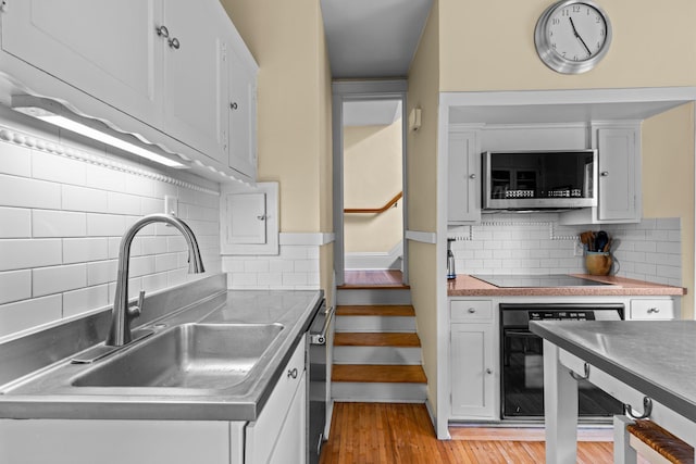 4817 Emerson Ave S, Minneapolis, MN 55419 - kitchen featuring black appliances, decorative backsplash, and white cabinets