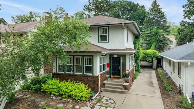 4817 Emerson Ave S, Minneapolis, MN 55419 - view of front of property featuring stucco siding, concrete driveway, brick siding, a chimney, and roof with shingles